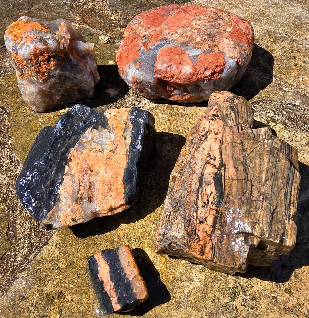 A mixed group of quartz and banded granite pieces.